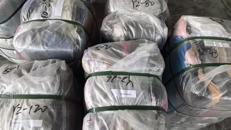 Incoming wrapped clothing bales ready for sorting and packing